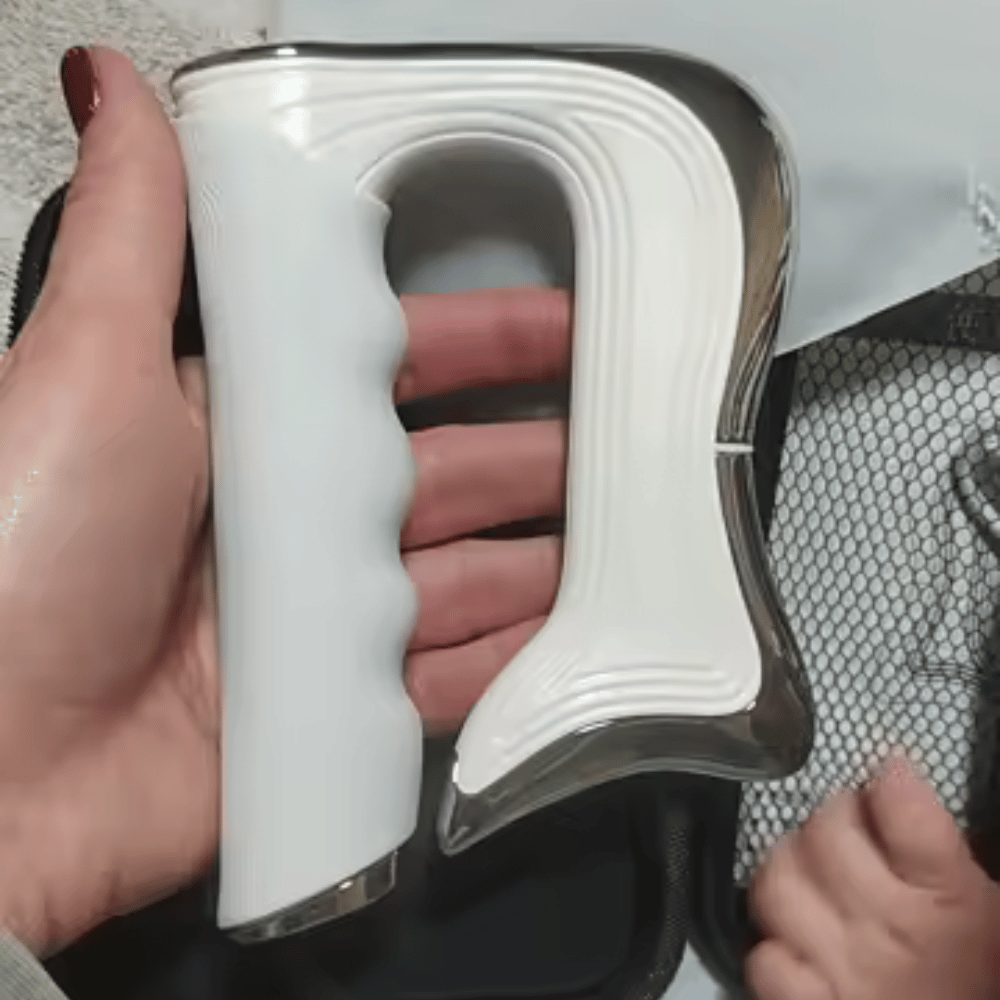 White handheld device with a textured grip held by a person.