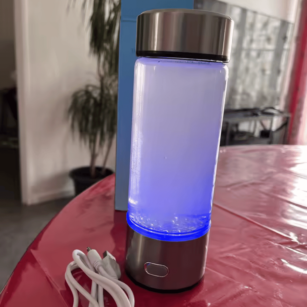 Blue-lit portable device on a red surface with a plant and desk in the background